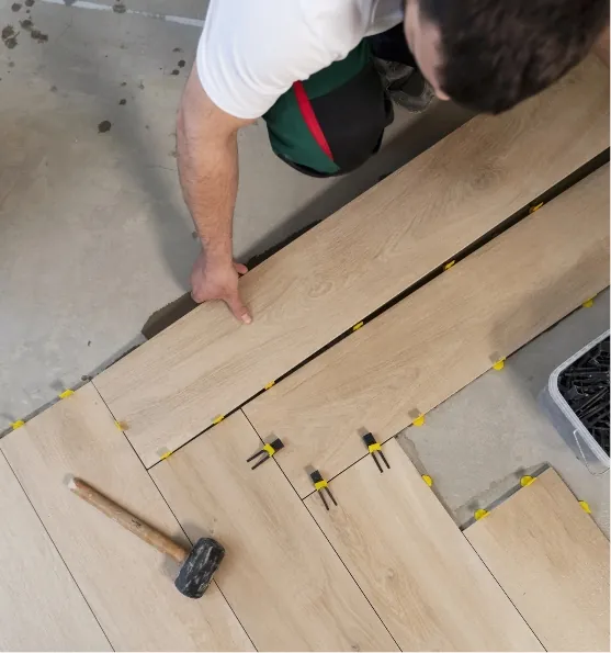 composicion de suelo con sujeccion de ceramica y obrero con martillo para nivelar